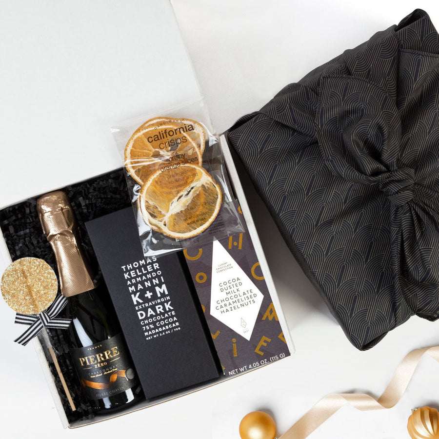 kadoo celebration gift box using eco-friendly furoshiki fabric wrap. Gifts include chocolate, sparkling wine 0% alcohol, orange slice & more.