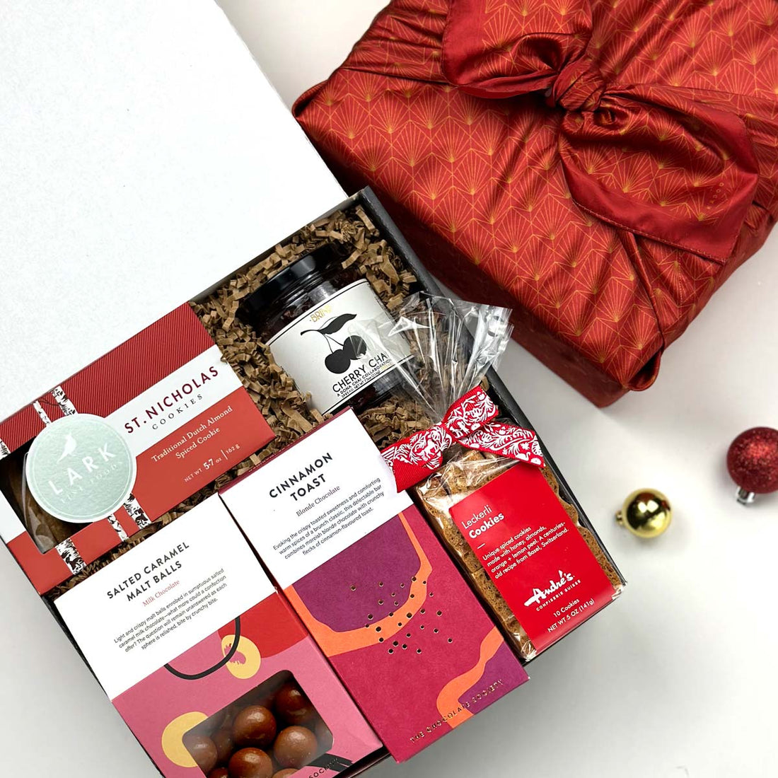 kadoo holiday cheers gift box with chocolate, cookies, jam, and more. Wrapped in reusable Furoshiki fabric.