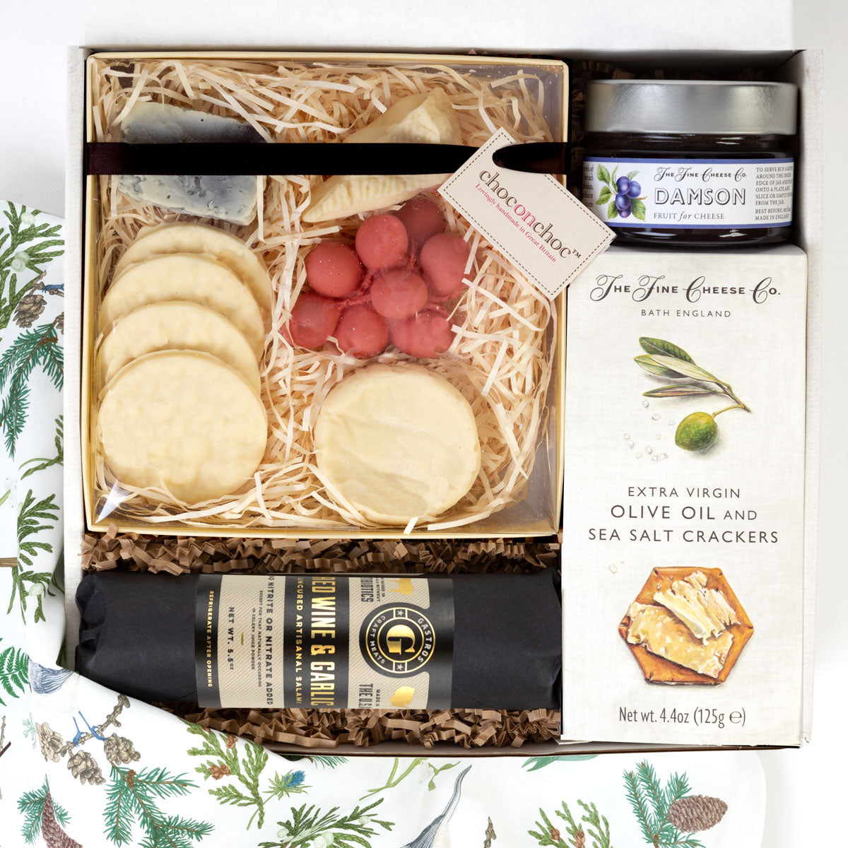 kadoo holiday cheese cracker gift box with chocolate cheese and crackers, extra virgin olive oil & sea salt crackers, jam for cheese, red wine and garlic salami.