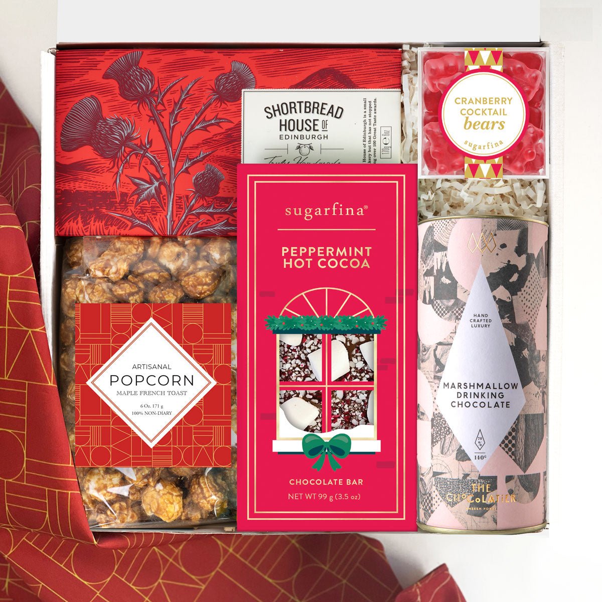 kadoo holiday festive gift box with dark chocolate cookies, gourmet popcorn, peppermint chocolate bar, cranberry cocktail gummy bears, marshmallow hot cocoa.