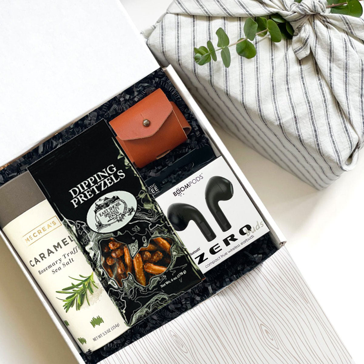 Kadoo Tech lover curated gift box for him. Featuring bluetooth earbuds, ipod leather case, caramels, pretzel &amp; more.