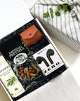 Kadoo Tech lover curated gift box for him. Featuring bluetooth earbuds, ipod leather case, caramels, pretzel & more.